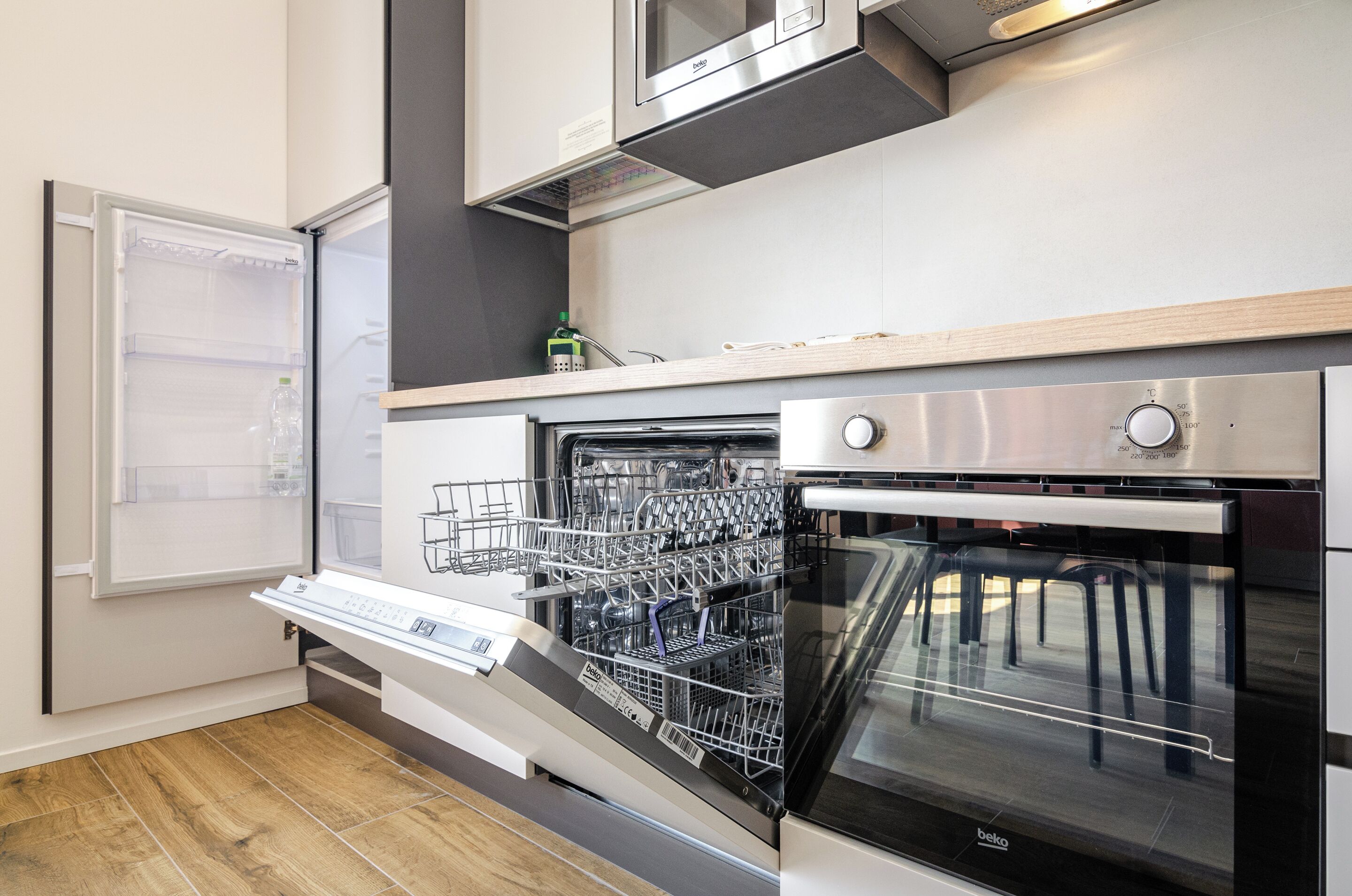 A modern kitchen with a built-in dishwasher, oven, and a microwave above the oven.