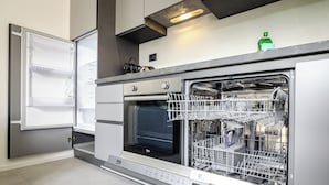 A modern kitchen with a built-in dishwasher, an oven, and a refrigerator.