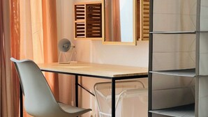 A compact workspace with a desk, chair, and shelving unit. - Central spacious apartment with roof terrace! (Bochum)