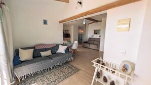 Een gezellige woonkamer met een bank, een bijzettafeltje en een vloerkleed.