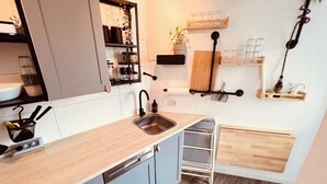 Pieni ja käytännöllinen keittiö, jossa on pesuallas, kaappeja ja pieni työtaso.