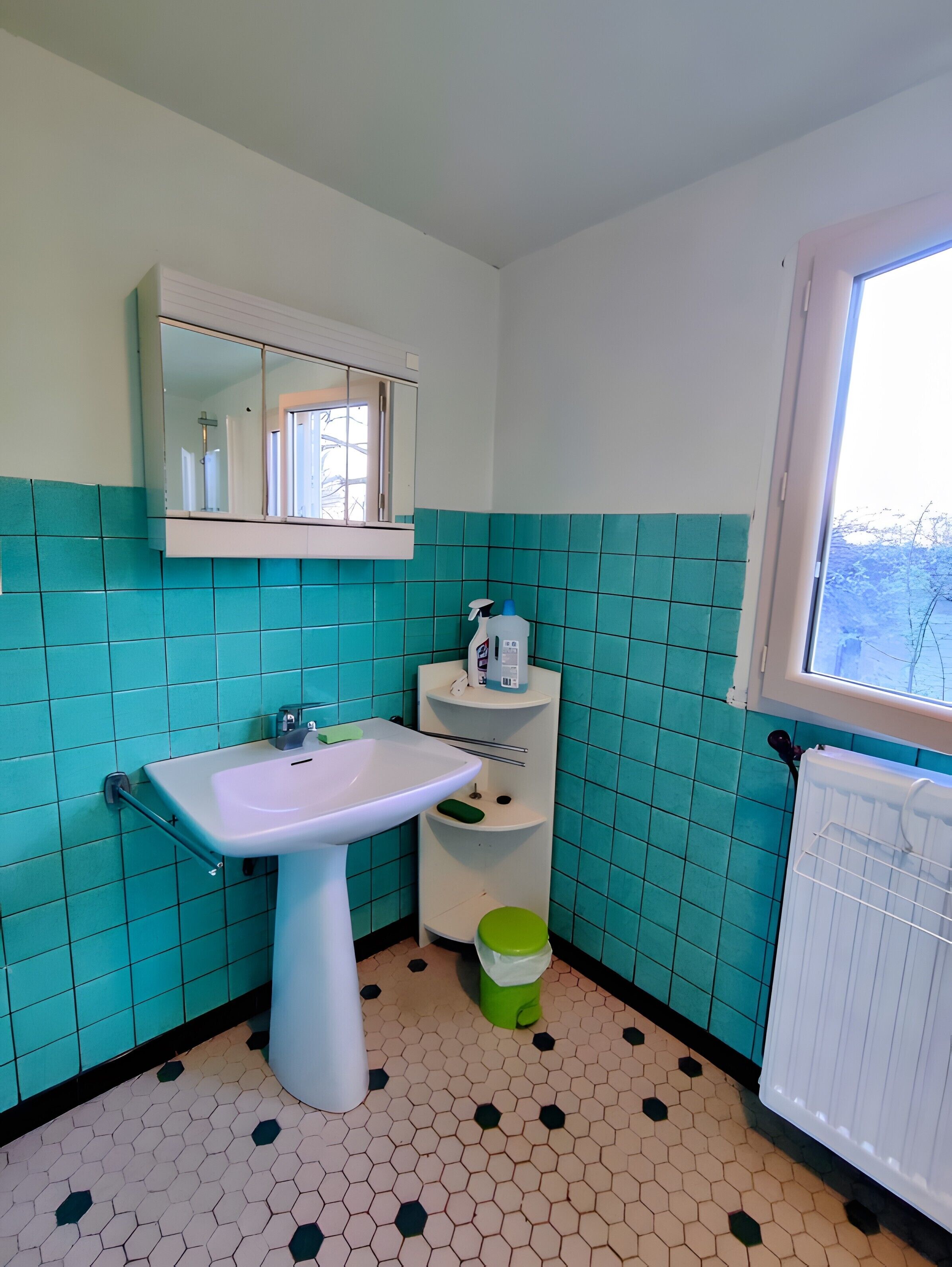 Ein Badezimmer mit Waschbecken, Spiegel und Fenster.