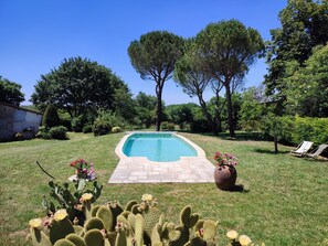 A swimming pool surrounded by grass, cacti, and trees. - Holiday Home "Maison 6 à 10 personnes" with Private Pool, Terrace and Wi-Fi (Sainte-Croix)