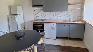 A compact kitchen with a built-in oven, a dishwasher, and a marble backsplash. - Holiday Home "Maison 6 à 10 personnes" with Private Pool, Terrace and Wi-Fi (Sainte-Croix)