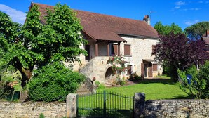 A stone house with a red-tiled roof, a stone staircase leading to the entrance, and a green lawn. - Holiday Home "Maison 6 à 10 personnes" with Private Pool, Terrace and Wi-Fi (Sainte-Croix)