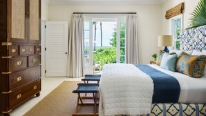 Quarto com cama, penteadeira, janela com cortinas, planta e vista para o verde lá fora.