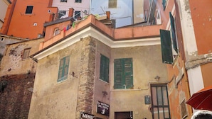 Une rue étroite bordée d’immeubles dotés de balcons et de volets.