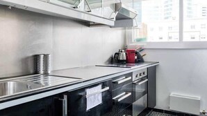 Een moderne keuken met een roestvrijstalen spoelbak, een waterkoker en een broodrooster op het aanrecht.