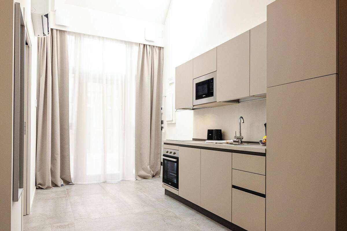 A modern kitchen with a skylight, built-in appliances, and a minimalist design.