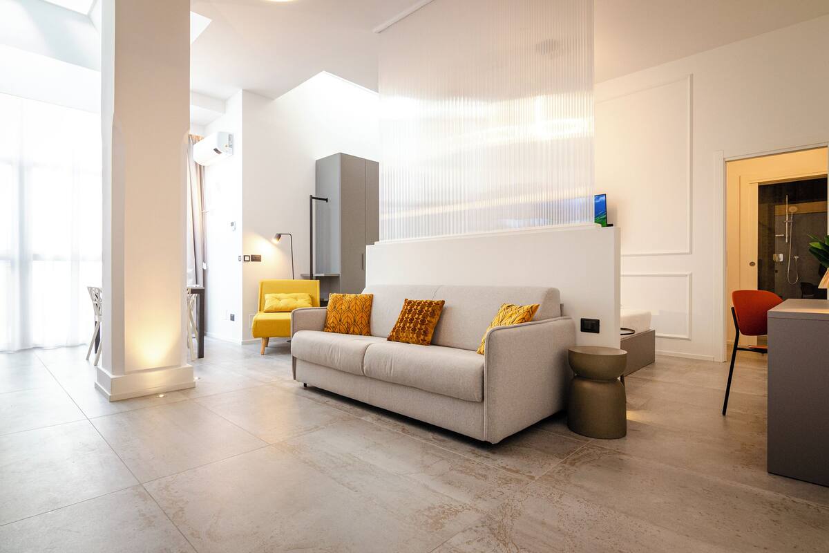 A modern living room with a sofa, a small side table, and a chair.