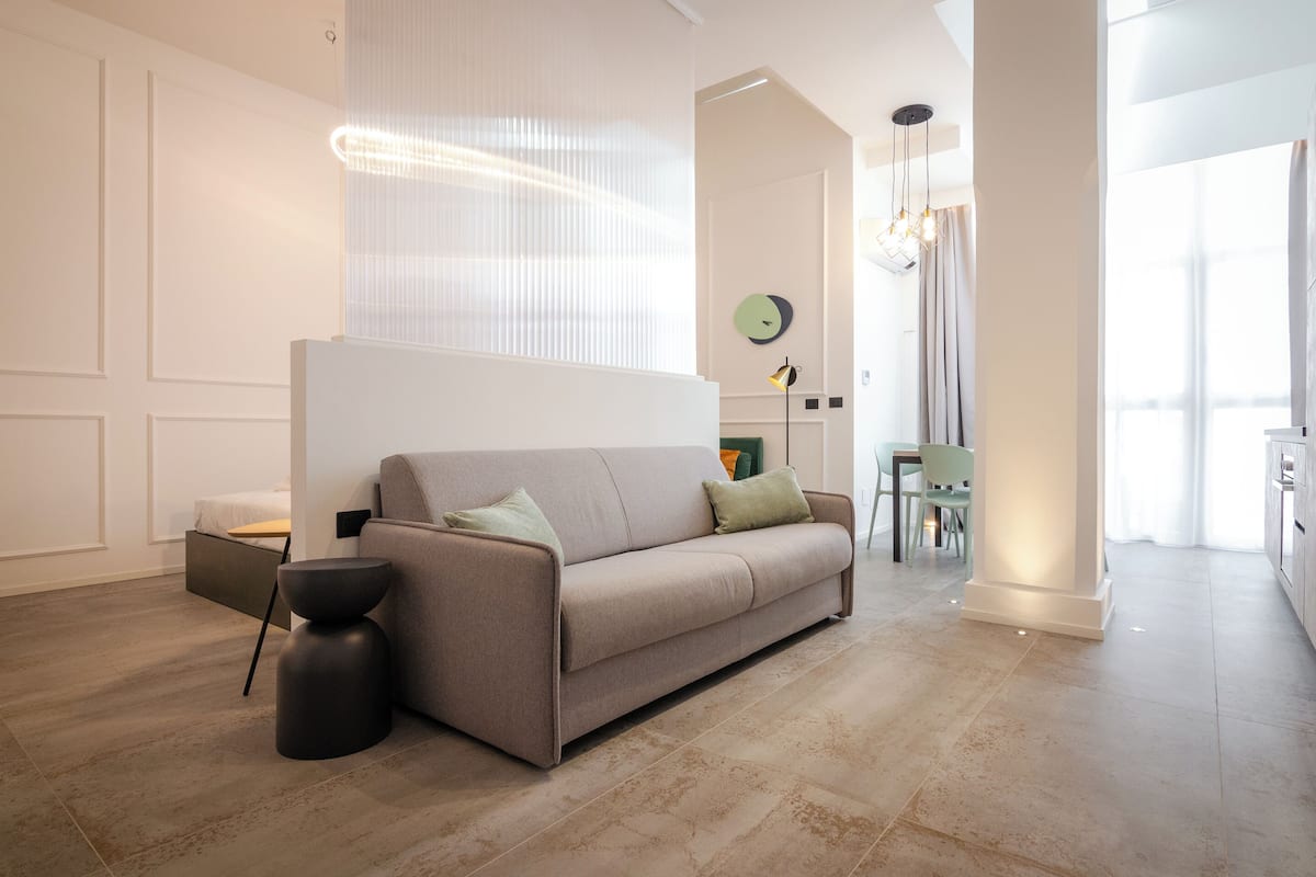 A modern living room with a sofa, a side table, and a lamp.
