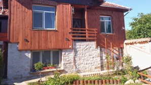 A two-story house with a stone facade, wooden exterior, and a tiled roof. - Charming Villa with AC, Barbecue and Pool  in peaceful Kramolin (Kramolin)