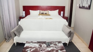 Habitació d'hotel amb un llit gran, una taula de nit, un escriptori i una cadira.