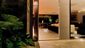An interior view of a modern hotel with a dining area, a sofa, and a large plant. - Luxury Mansion VILLA MARIA (brand new) (Tibau do Sul- RN)