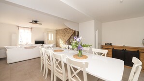 A modern kitchen with white cabinetry, a wooden countertop, and a built-in oven. - Holiday Home 'Refuge du Sentier Sauvage' with Private Terrace (Belz)