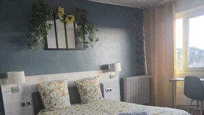 A bedroom with a bed, bedside tables, a radiator, a desk, and a window. - Large T5 for 7 people (Angers)