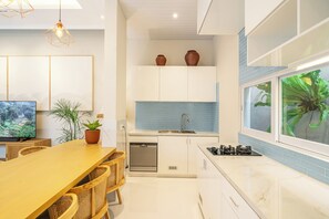 Eine moderne Küche mit Essbereich, Einbau-Schränken, einem Geschirrspüler und einem großen Fenster mit Blick.