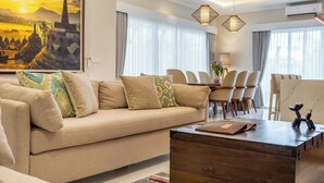 A modern living room with a sofa, dining table, chairs, and a coffee table. - Modern Luxury 6Br Villa In Canggu - Rooftop - Ricefields - Large Groups (Tabanan)
