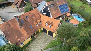 Ein Wohngebiet mit mehreren Häusern, manche mit Solaranlagen, einem Schwimmbad und einer gepflasterten Auffahrt.