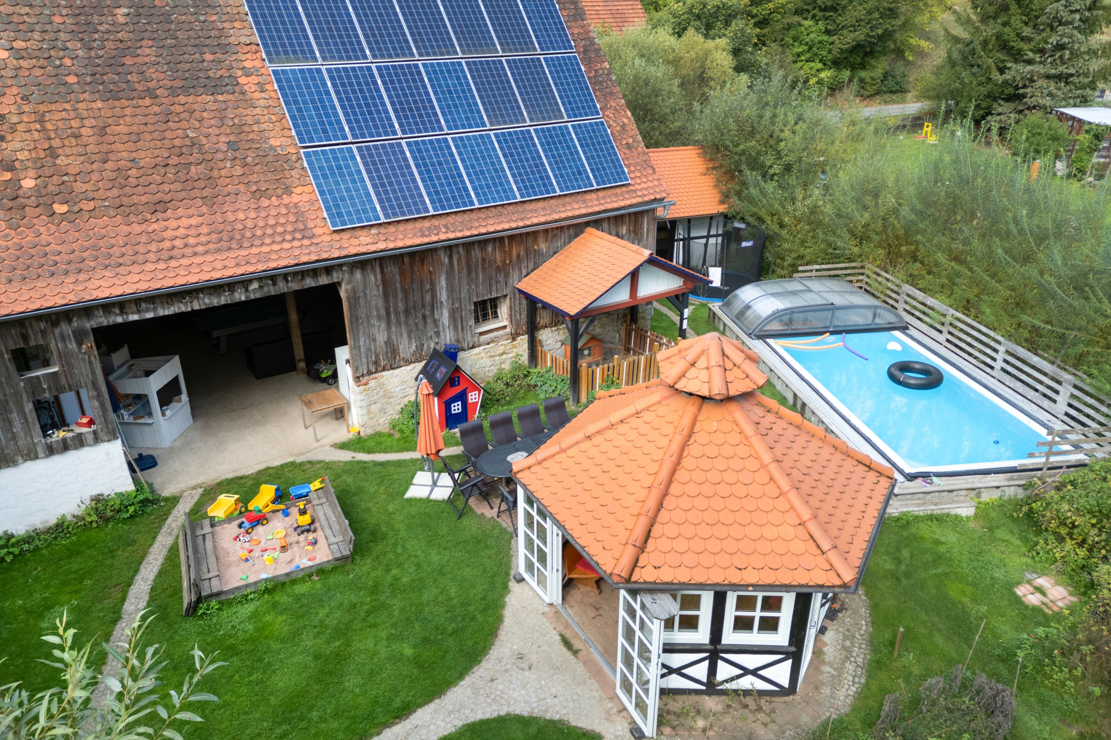 Una casa con garaje, piscina y una zona de juegos pequeña.