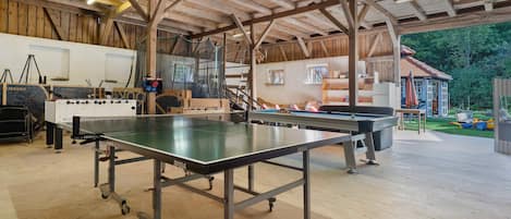 Amplio espacio interior con mesa de ping pong, mesa de fútbol de mesa y mesa de billar.