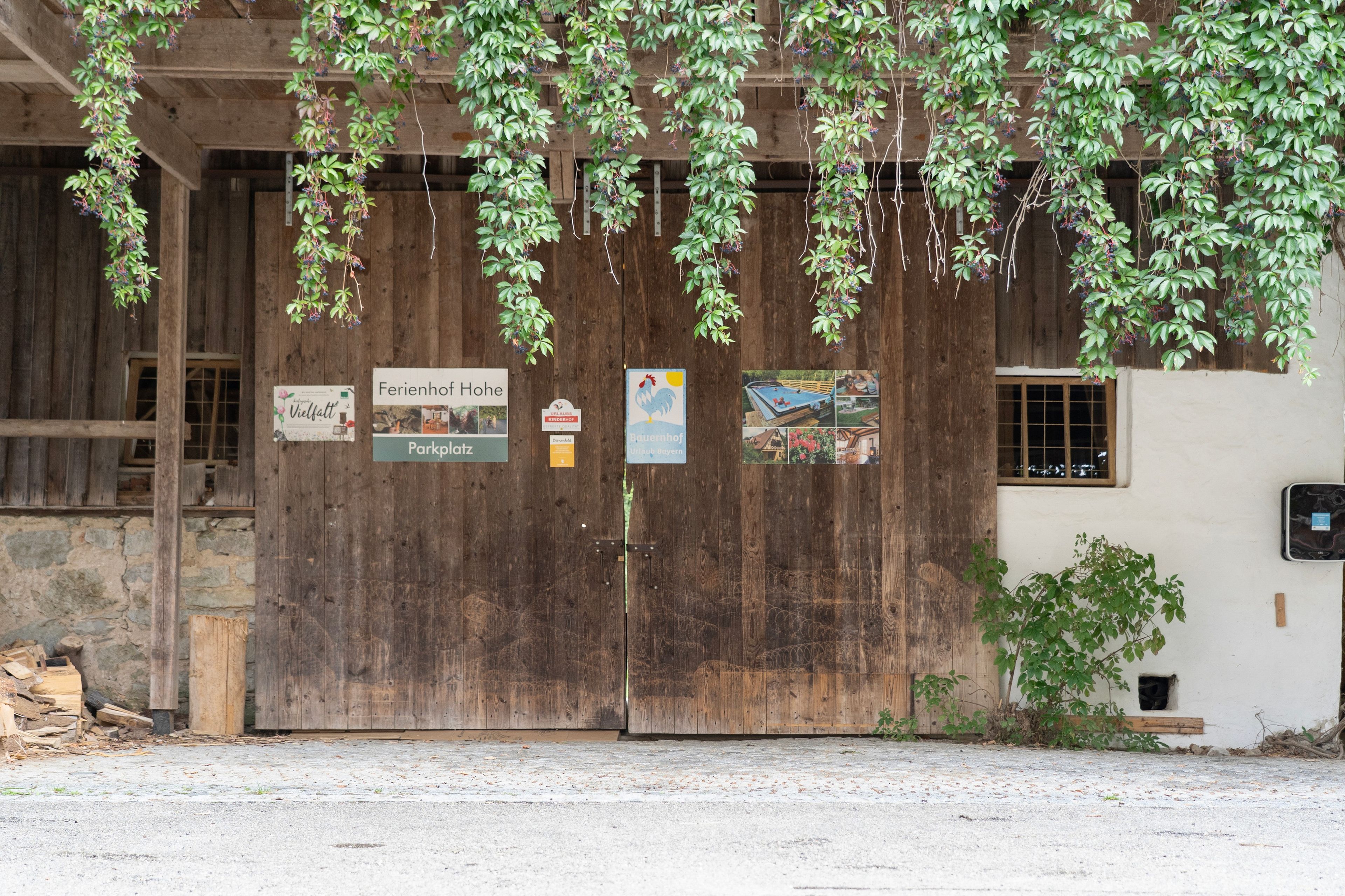 Un bâtiment rustique en bois, doté d’une grande porte, d’enseignes indiquant la présence d’un parc et d’une brasserie, ainsi que d’une petite fenêtre.