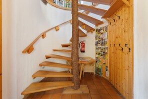 A spiral wooden staircase with a fire extinguisher on the wall. - Drei Zinnen Holiday Apartment (Hiltpoltstein)