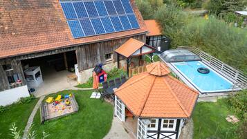 Ein Haus mit Garage, Schwimmbad und einer kleinen Spielgegend.