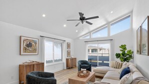 A spacious living room with a sofa, armchair, and coffee table. - Outrigger Beach Retreat w/ Private Path & Firepit (Oxnard)