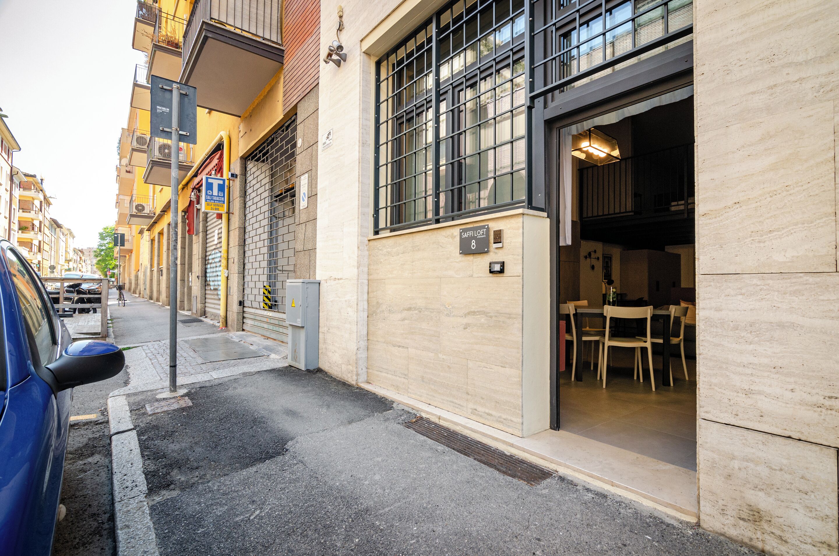 Een gebouw met een restaurant op de begane grond, een duidelijke ingang en een parkeerplaats.