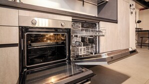An open oven with a dishwasher installed next to it. - Saffi Lofts (Bologna)