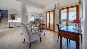 A spacious living area with a dining table, a sofa, and a chair. There is a staircase leading to another level. - Villa 151 Luxury Villa - Private Pool and Tennis Court (Kouklia)