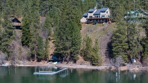 A lakeside property with a large house, a dock, and a small cabin.