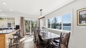 A spacious kitchen with a large island, wooden chairs, and a view of the outdoors.