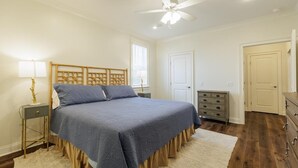 A bedroom with a bed, a nightstand, a dresser, a ceiling fan, and a window. - Executive condo...traveling professionals, look no further! (Valdosta)