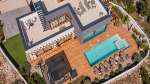 Uma villa moderna com piscina no terraço, área de estar externa e hidromassagem.