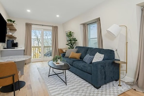 A modern living room with a sofa, coffee table, and a lamp.