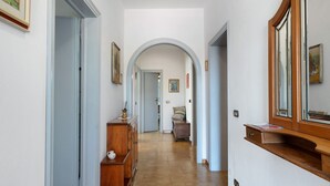 A hallway with a wooden cabinet, a mirror, and a door leading to another room. - Casa Teresa with Mountain View, Private Terrace, and Wi-Fi (Loppeglia)