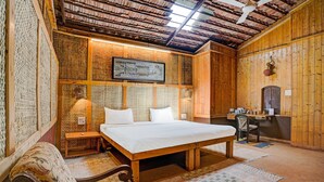 A traditional wooden room with a bed, a desk, and a chair. - Palette Palghar Irayos Resort (Dahanu)