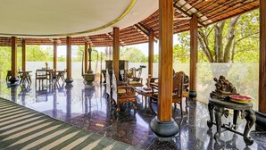 A spacious indoor area with a polished floor, wooden furniture, and large windows allowing natural light. - Palette Palghar Irayos Resort (Dahanu)
