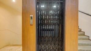A metal gate with a keypad, a staircase to the right, and a marble floor.