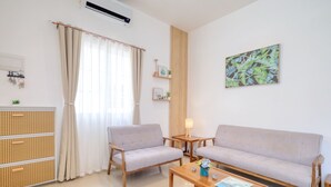 A modern living room with a sofa, two armchairs, a coffee table, a lamp, and a wall-mounted artwork. - 3BR Guesthouse near Panglao • Pool • Bohol Tours (Dauis)