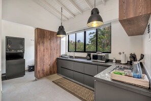 Une cuisine moderne dotée d’une grande fenêtre, d’un four encastré et d’un four à micro-ondes.