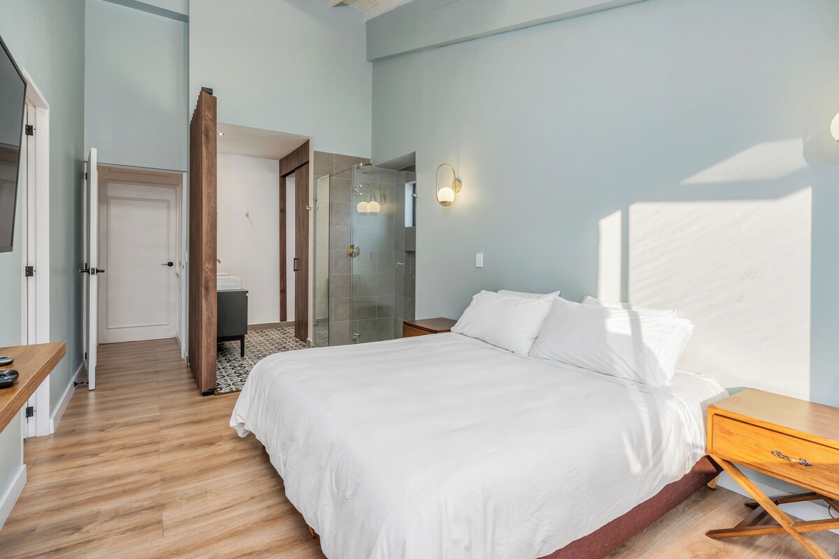 A bedroom with a bed, bedside table, and a walk-in closet.