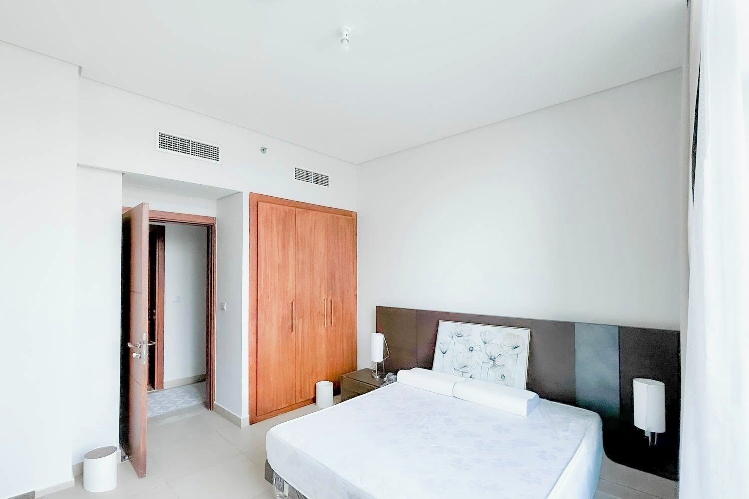 Um quarto moderno com uma cama, um guarda-roupa e uma mesa de cabeceira.