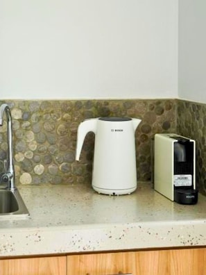 Une cuisine équipée d’une bouilloire Bosch, d’une machine à café et d’un évier.