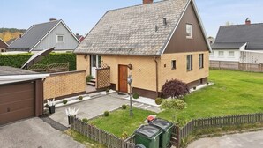 A single-story house with a sloped roof, a front door, and a small front yard.