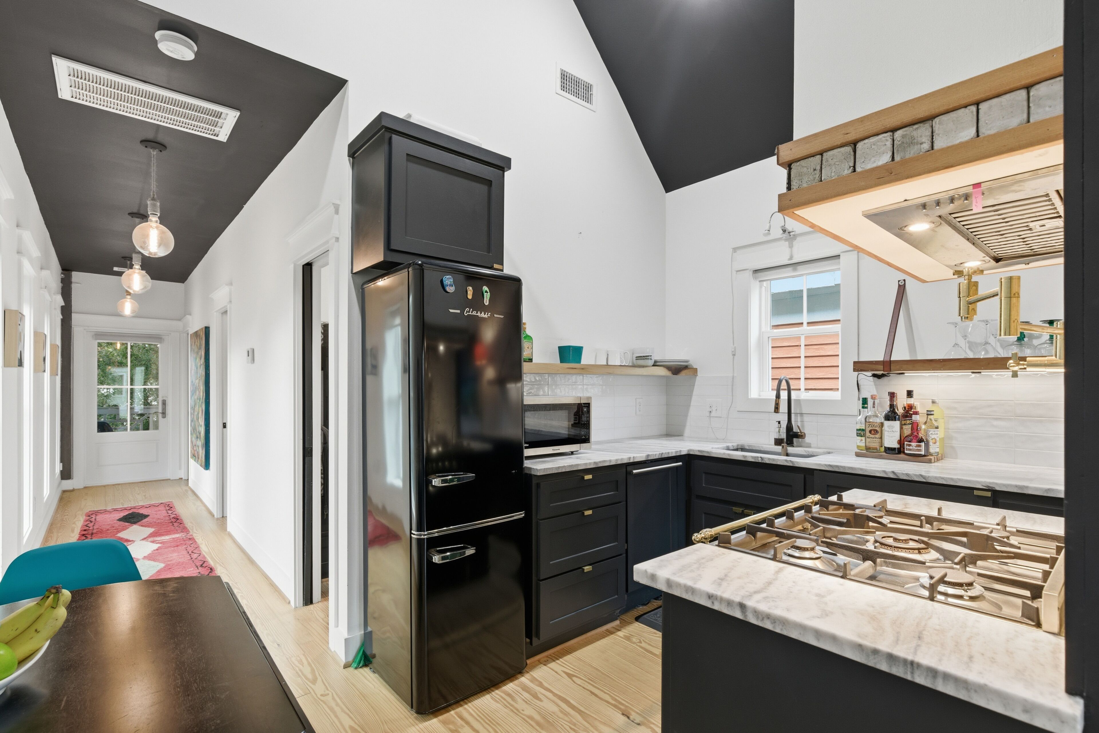 Una cucina moderna con un frigorifero nero, un piano cottura a gas e un forno a microonde.