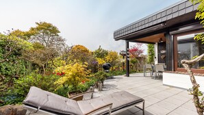 An outdoor patio with lounge chairs, a barbecue grill, and a dining area with chairs and a table. - Very comfortable house in the Hamburg area (Kisdorf)