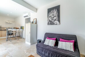 Un espace de vie moderne comprenant un canapé, une table à manger et des chaises.
